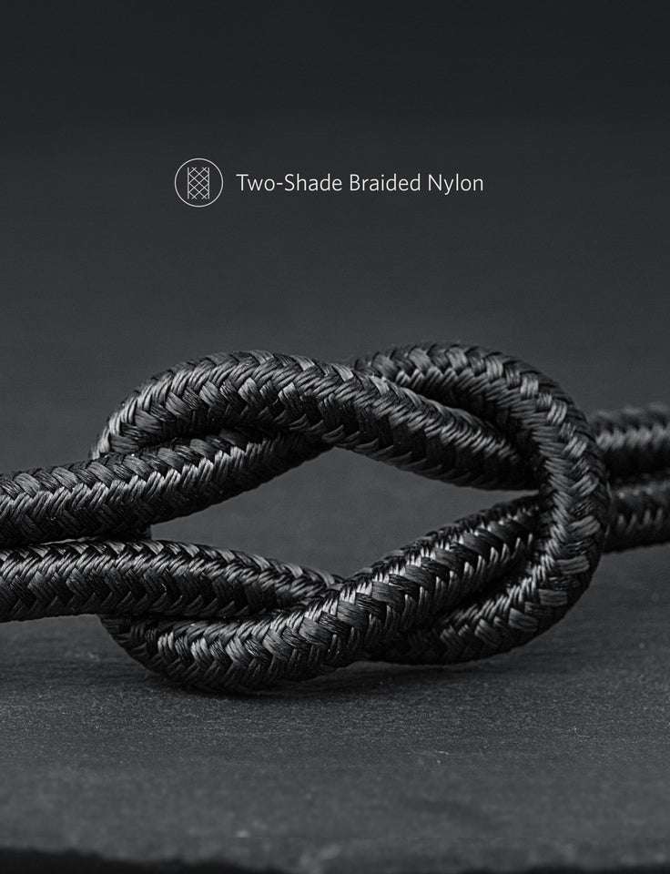 Two-tone black braided nylon cable, coiled close-up