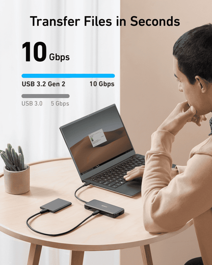 USB-C hub with compact dark gray body connected to a laptop