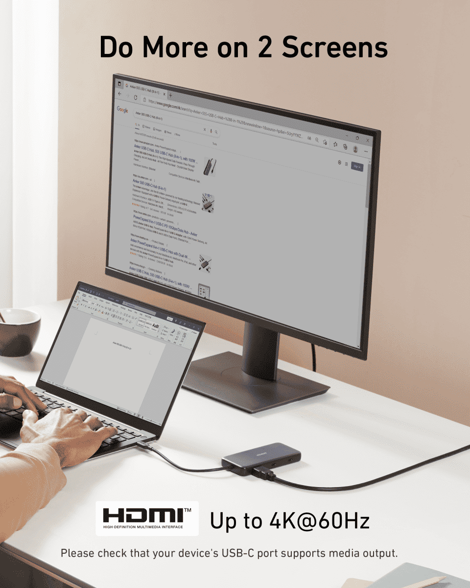 USB-C hub connected to a monitor and laptop, dark gray compact design