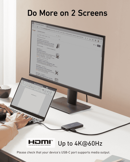 USB-C hub connected to a monitor and laptop, dark gray compact design