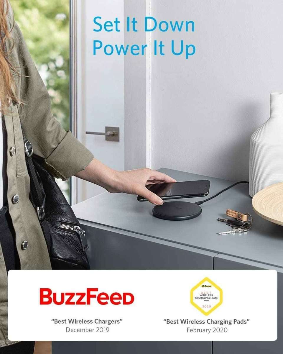 Wireless charging pad on a desk with a phone resting on top