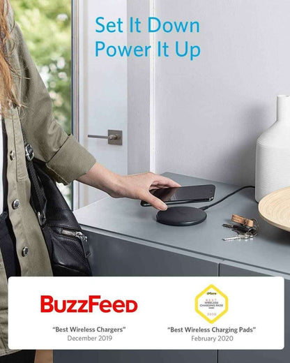 Wireless charging pad on a desk with a phone resting on top