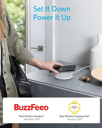 Wireless charging pad on a desk as a person charges a smartphone