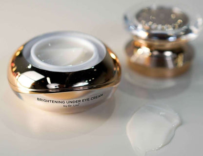 Black and gold under-eye cream jar with white cream and raised lid