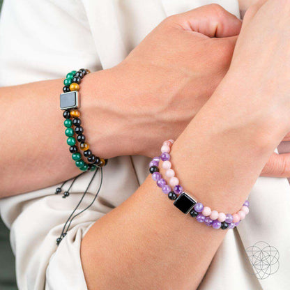 Beaded bracelet on wrist with black and green beads, amber bead accents, square charm