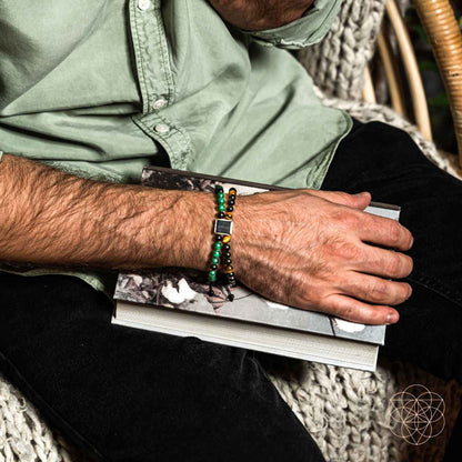 Beaded bracelet with black and green beads and amber accents, square metal center