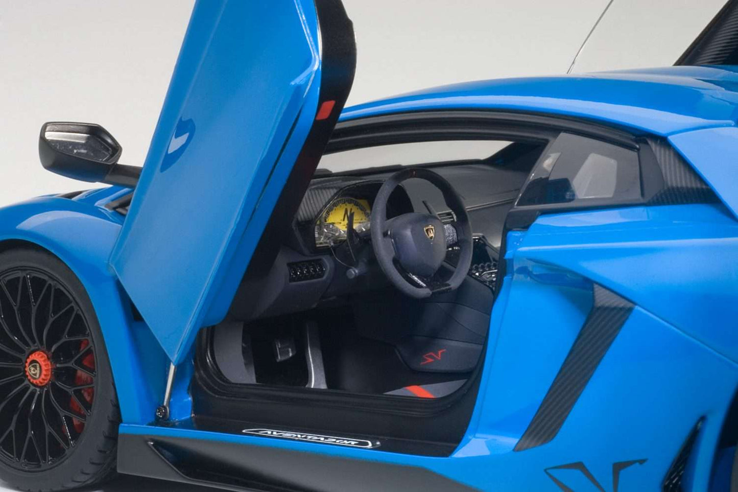 Blue 1:18 scale die-cast sports car, open driver door interior view