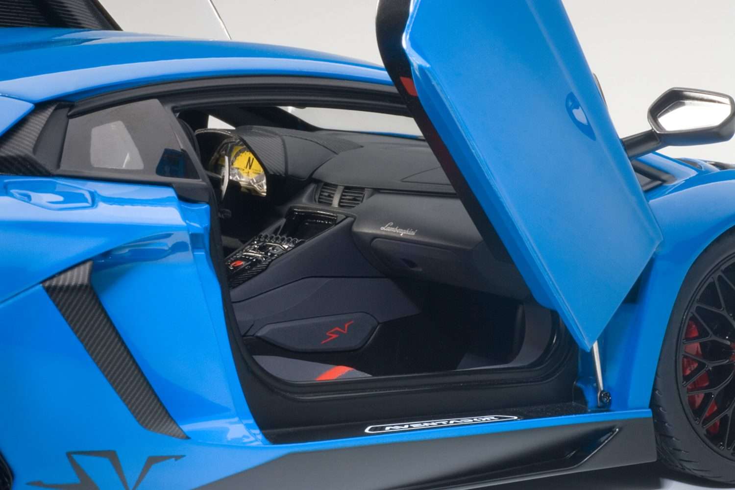 Blue 1:18 scale die-cast sports car, open door side interior view