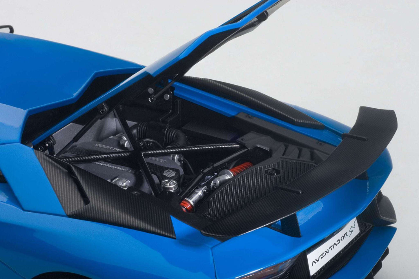 Blue sports car model with detailed engine compartment and carbon-style panels