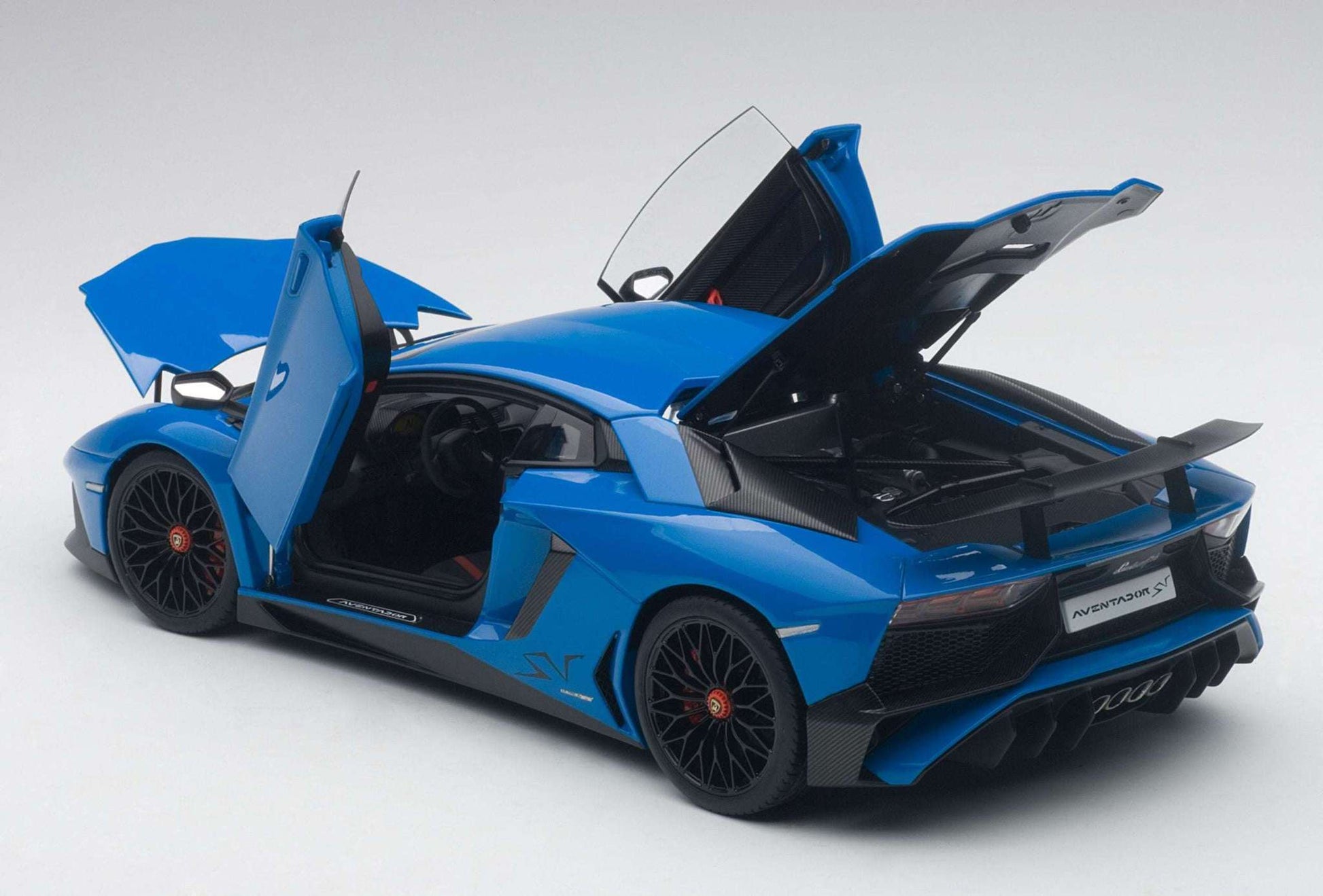 Blue sports car model with open scissor doors and raised rear hood