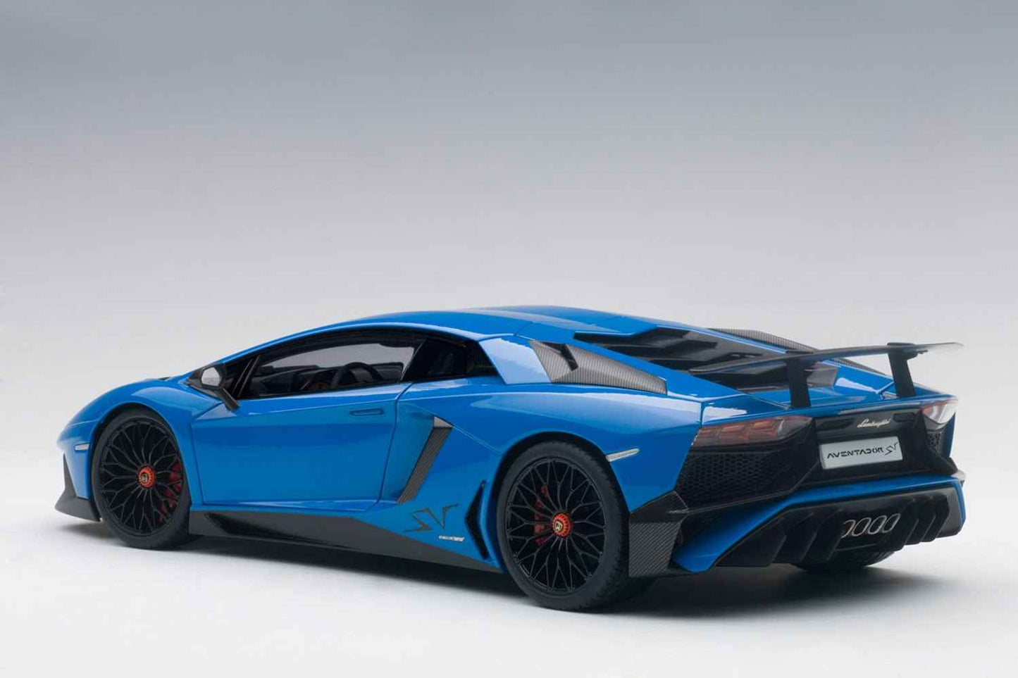 Blue 1:18 scale die-cast sports car, rear-left three-quarter view