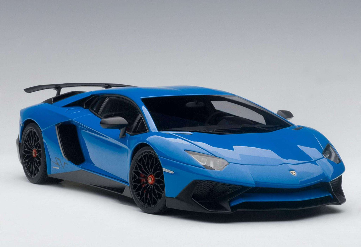 Blue sports car model in side view with black wheels and aerodynamic vents