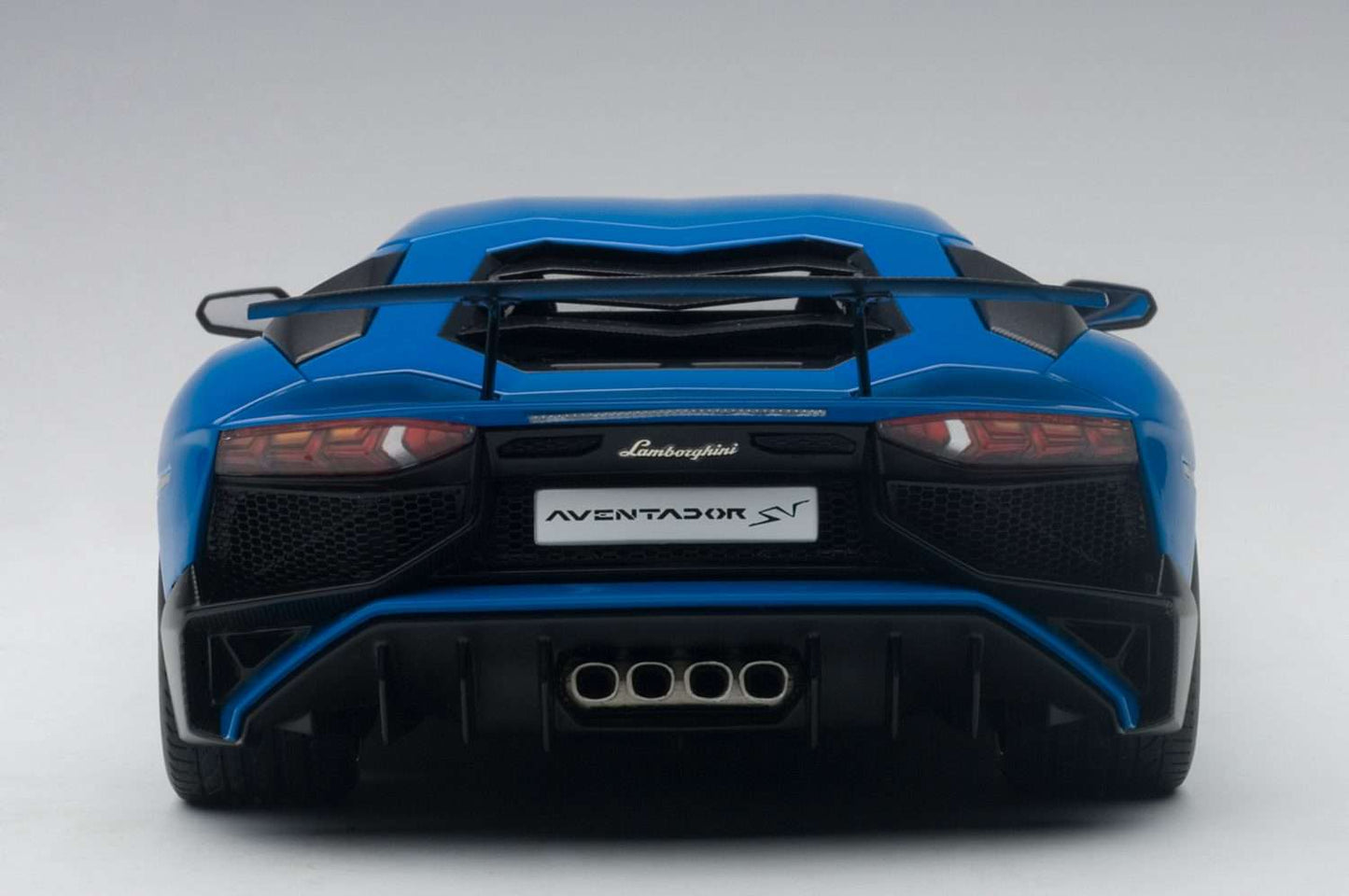 Blue 1:18 scale die-cast sports car, rear view with quad exhaust