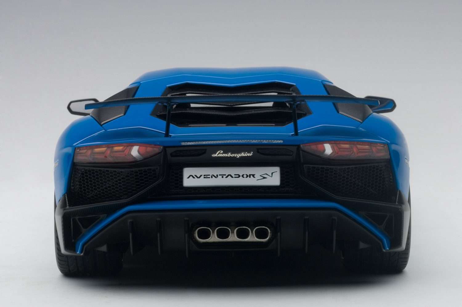 Blue 1:18 scale die-cast sports car, rear view with quad exhaust