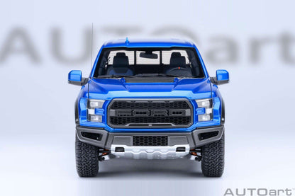 Blue pickup truck model front view with large black grille, fog lights, and knobby tires