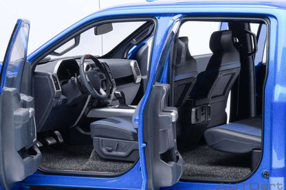 Blue pickup truck model interior with driver seat, steering wheel, and dark floor mat