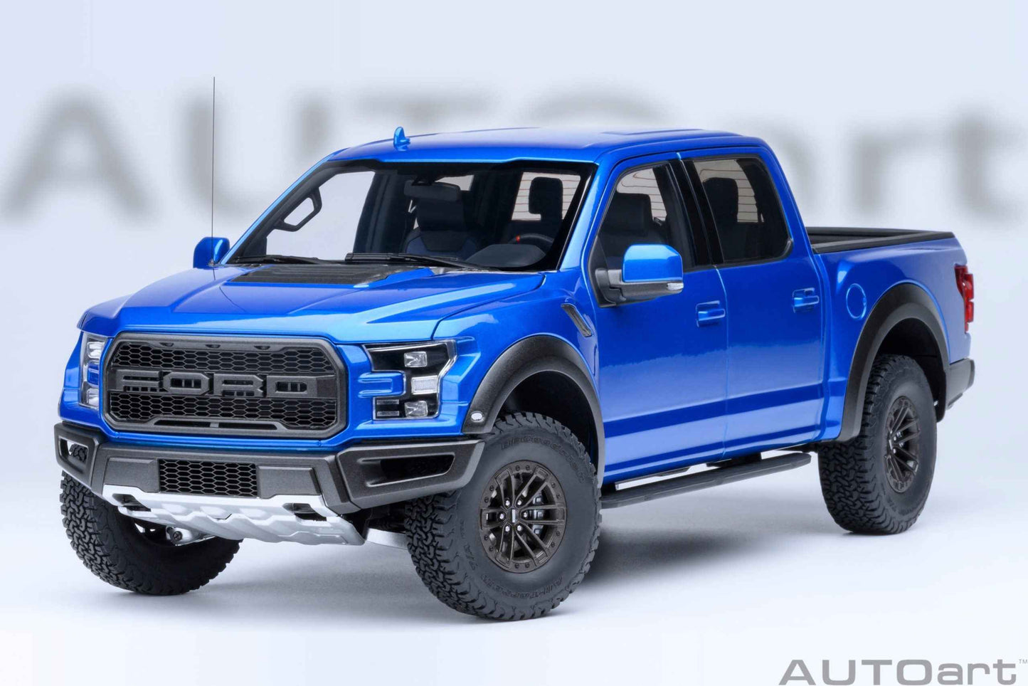 Blue pickup truck model with detailed front grille, headlights, and black wheels, angled view