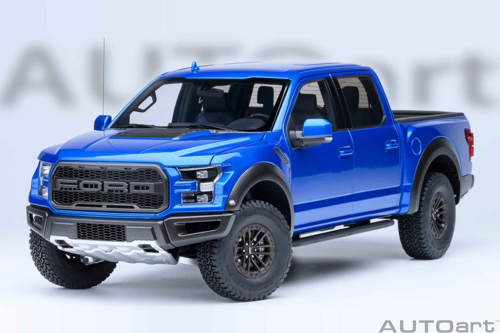 Blue pickup truck model with detailed front grille, headlights, and black wheels, angled view