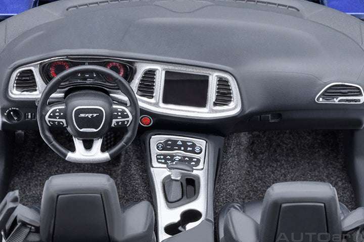 Blue die-cast sports car interior, black dashboard, steering wheel, and center console.