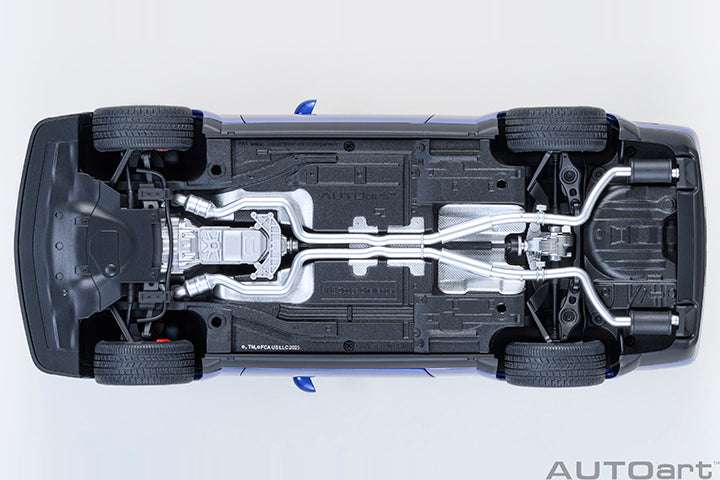 Undercarriage view die-cast sports car model with exposed mechanical parts and black tires