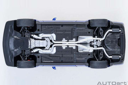 Undercarriage view die-cast sports car model with exposed mechanical parts and black tires