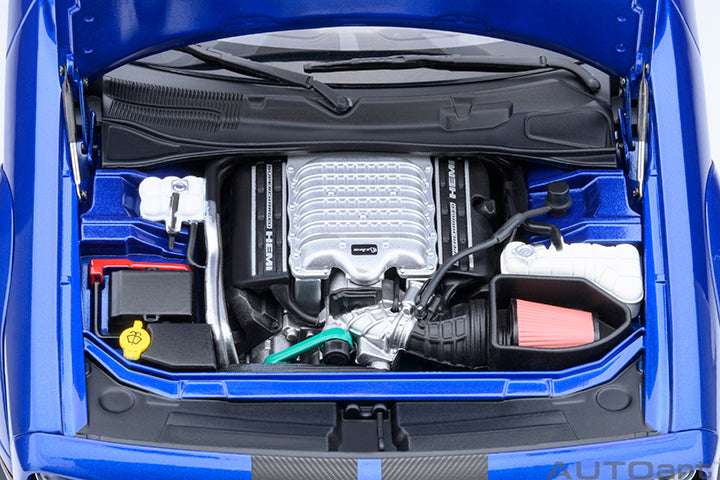 Blue die-cast sports car engine bay close-up with silver engine cover and hoses.