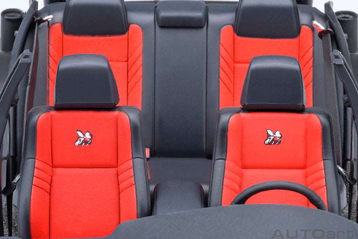 Front-seat view of gray die-cast Charger model with red upholstery and black headrests.