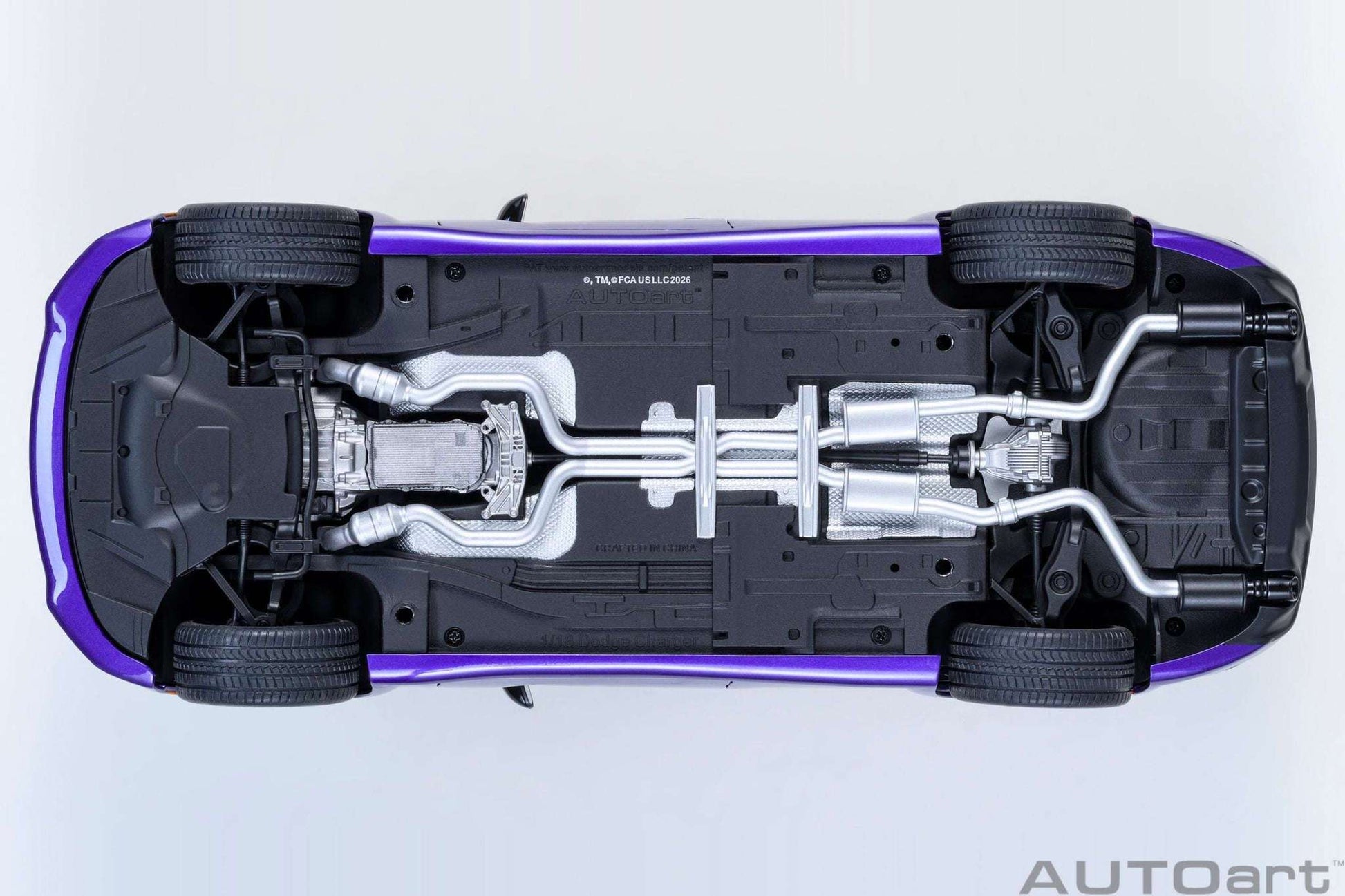 AUTOart 1:18 scale purple Dodge Charger model, underside view with exposed drivetrain