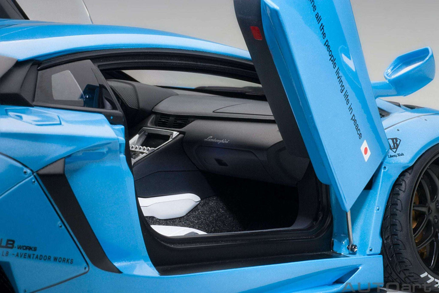 Metallic sky blue Lamborghini Aventador model car with open door and black interior