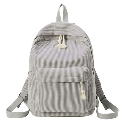 Light gray mini backpack with front panel pocket and tassel zipper pull