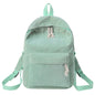 Mint green backpack with tassel drawstring, front zip pocket, and adjustable shoulder straps