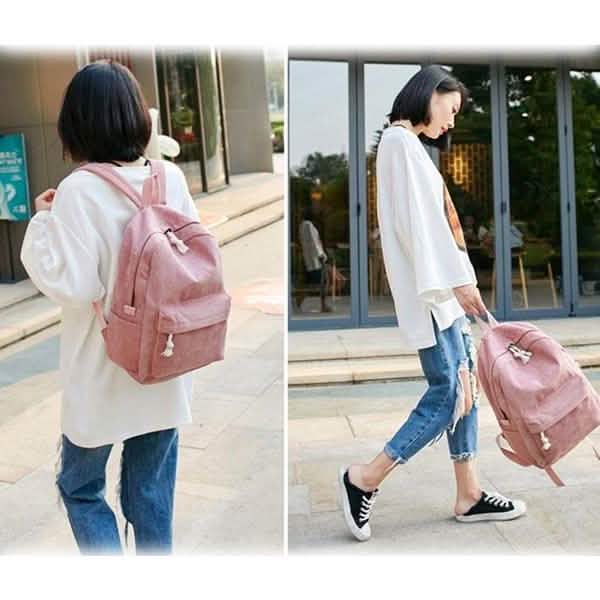 Pink backpack worn on back with tassel drawstring and front pocket