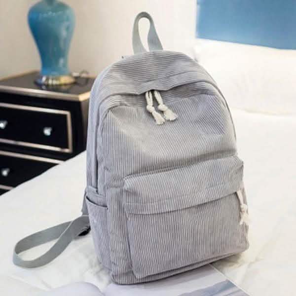 Gray backpack with front pocket and tassel drawstring, side shoulder strap
