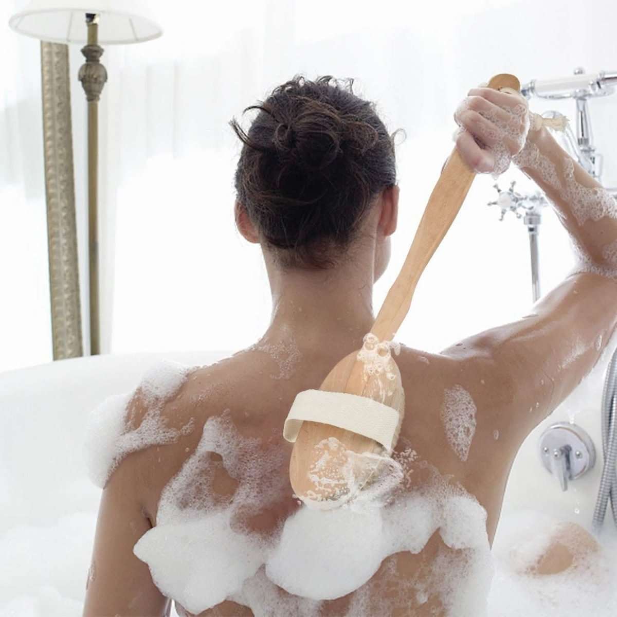 15 in shower body back scrubber with long handle and oval brush head, in use on skin
