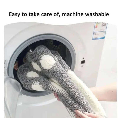 Gray paw-print bathroom rug mat with white pads, in a washing machine