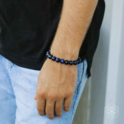 Blue beaded bracelet worn on a wrist, close-up of the round beads