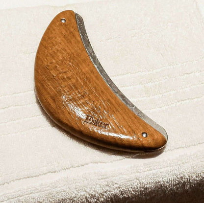 Wooden half-moon body exfoliator tool with metal edge and two holes