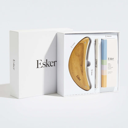Exfoliation tool set in white packaging with wooden blade and oil bottles
