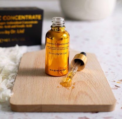 Amber vitamin C concentrate serum bottle with glass dropper on wooden board