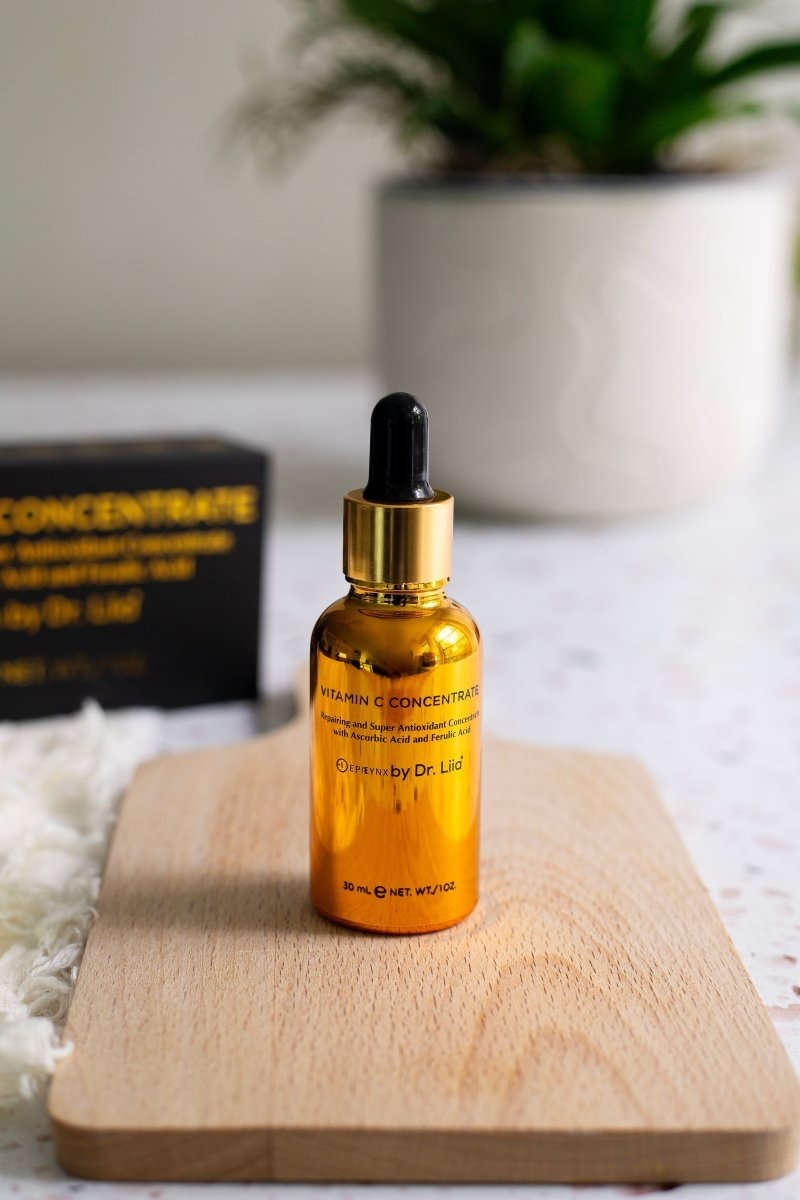 Amber Vitamin C serum bottle with black dropper on light wood tray