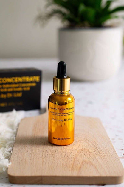 Amber Vitamin C serum bottle with black dropper on light wood tray