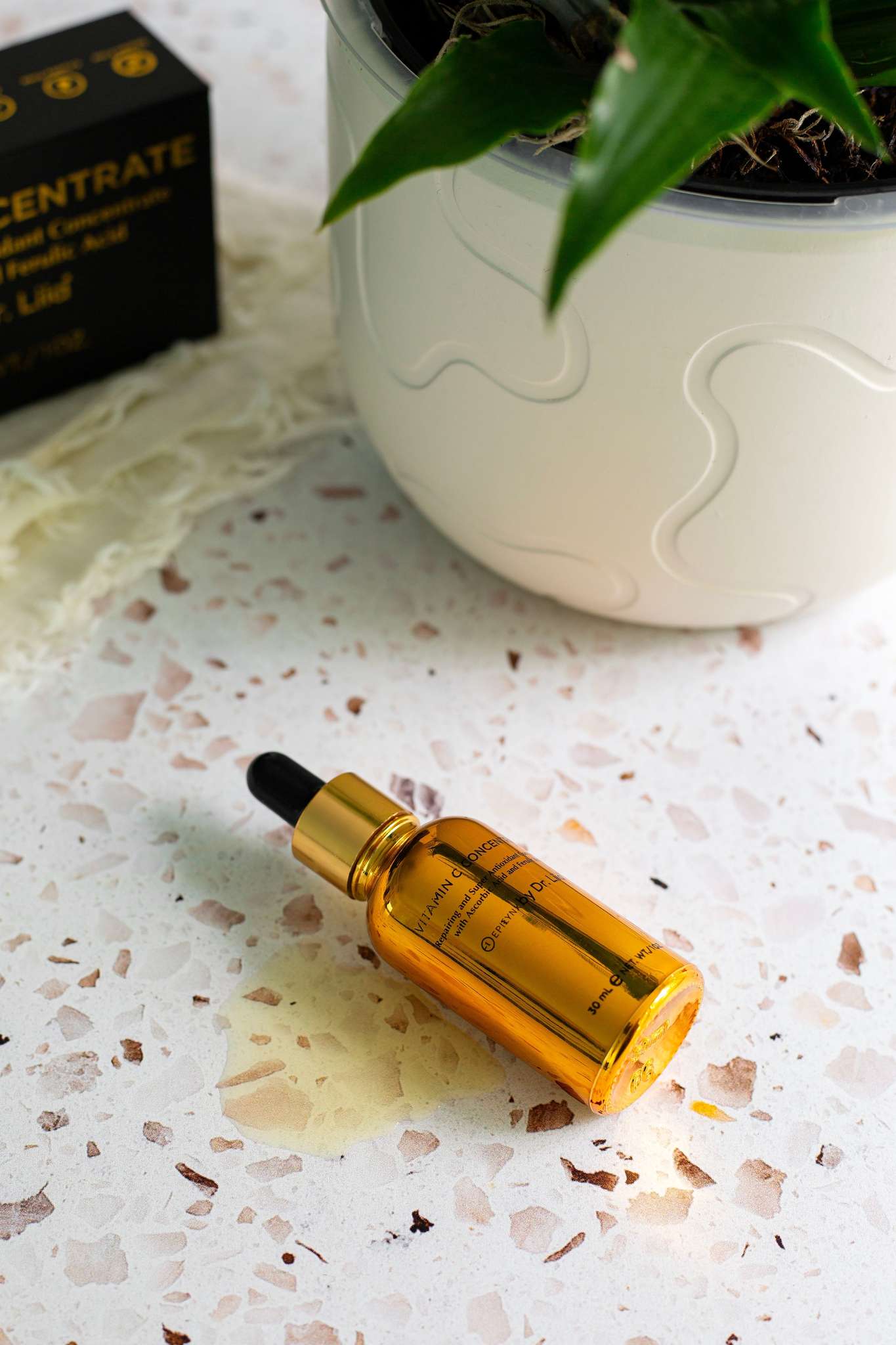 Amber Vitamin C serum bottle lying with dropper on white surface