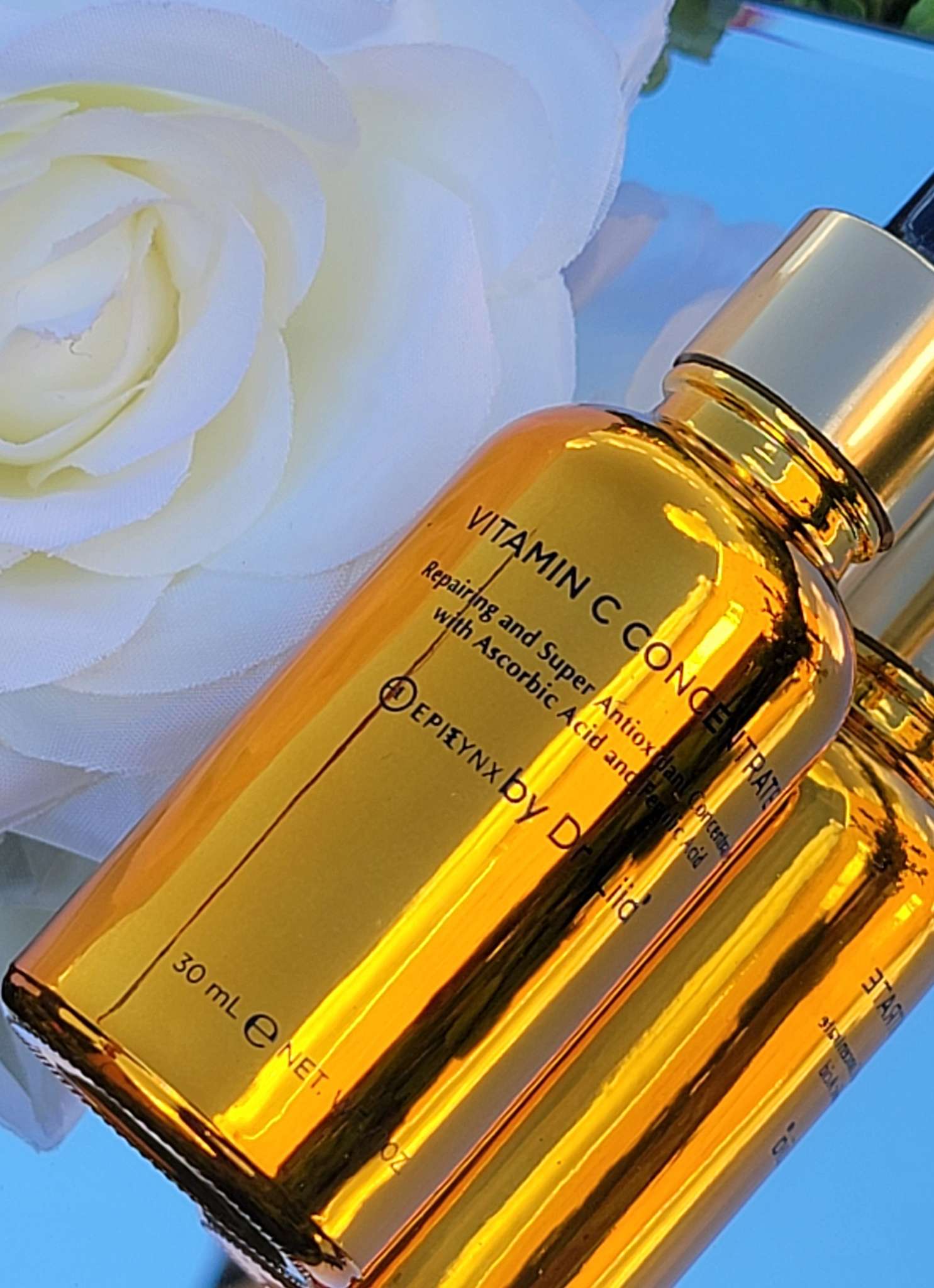 Amber vitamin C serum bottle close-up with gold cap and embossed label