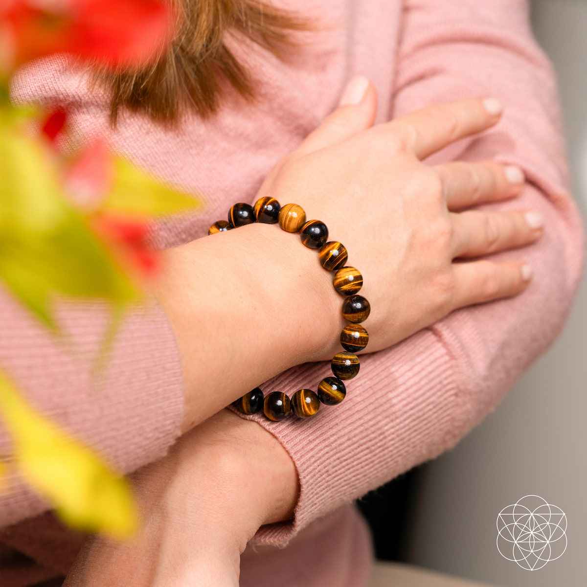 Tiger's eye bead bracelet on wrist with glossy round striped beads.