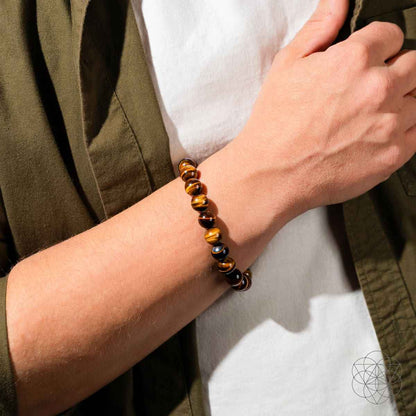 Tiger's eye bead bracelet on wrist with dark-brown and gold striped round beads.