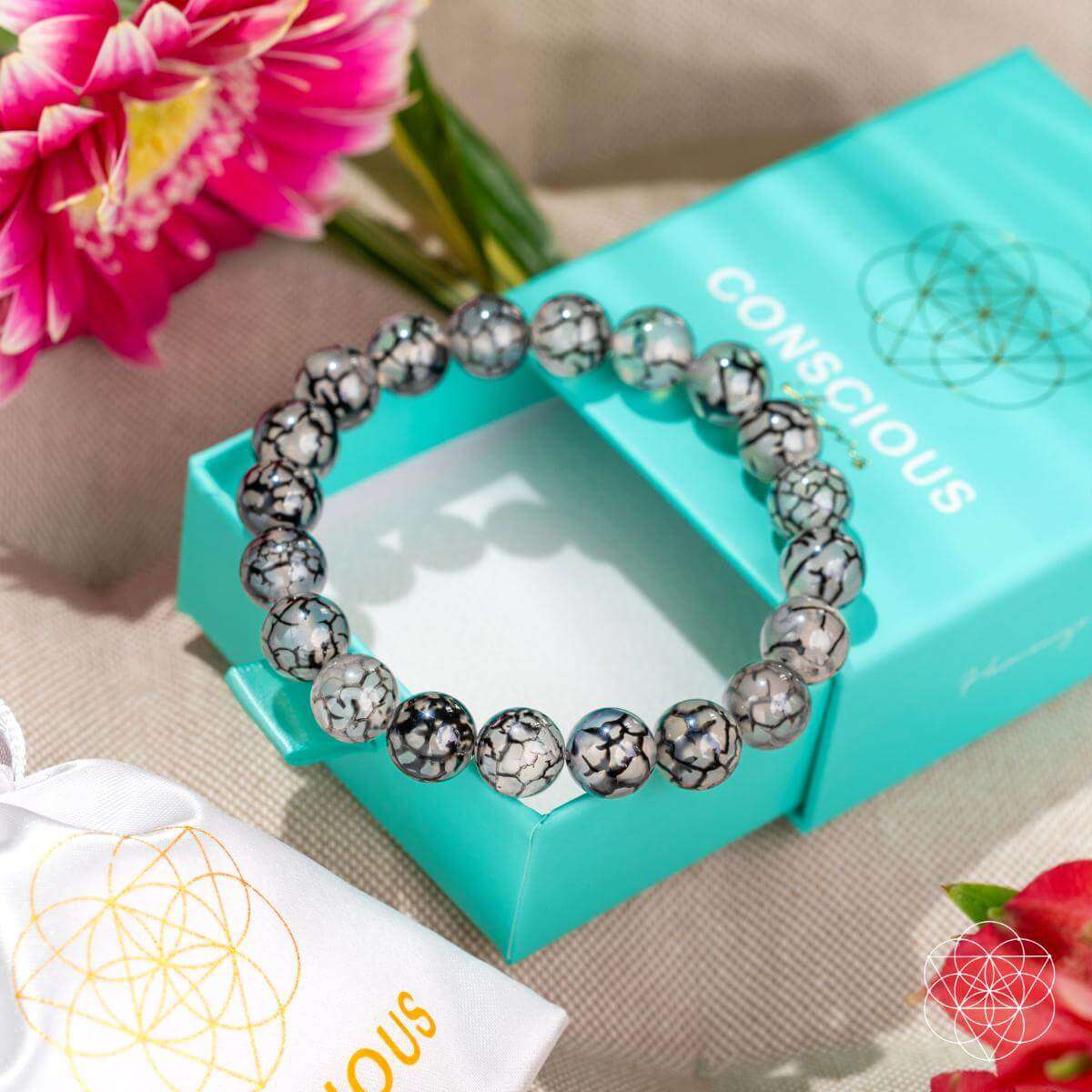 River agate beaded bracelet on teal box, gray-and-black marbled beads in a circle