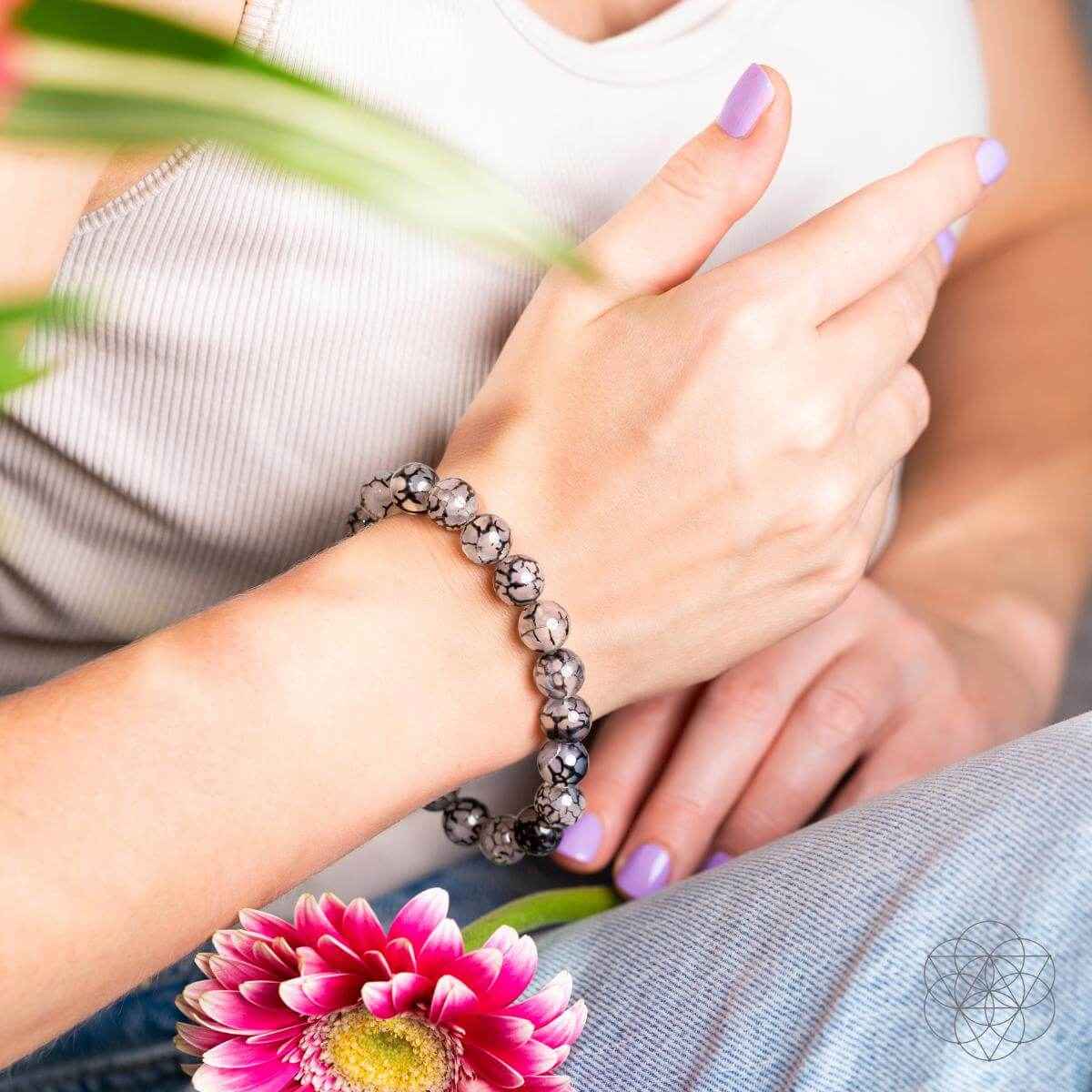 River agate bracelet on wrist, gray-and-black marbled bead pattern with sparkling accents