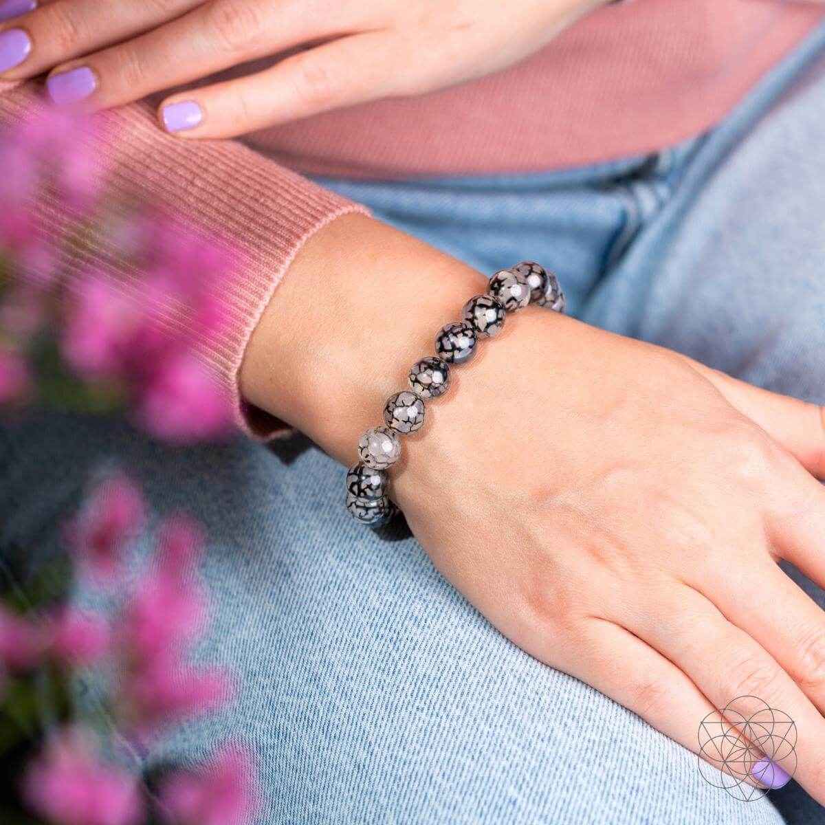 River agate beaded bracelet on arm, gray-and-black marbled round beads in elastic band