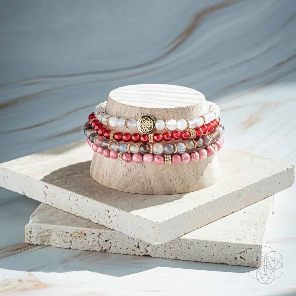 Beaded bracelet set of 4 with red, pink, and white bead strands and gold charm