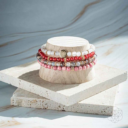 Beaded bracelet set of 4 with red, pink, and white bead strands and gold charm
